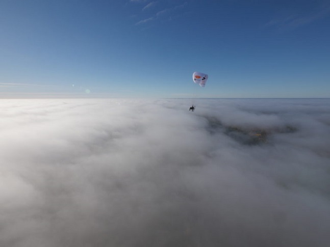 Sacha Dench in her paramotor above clouds