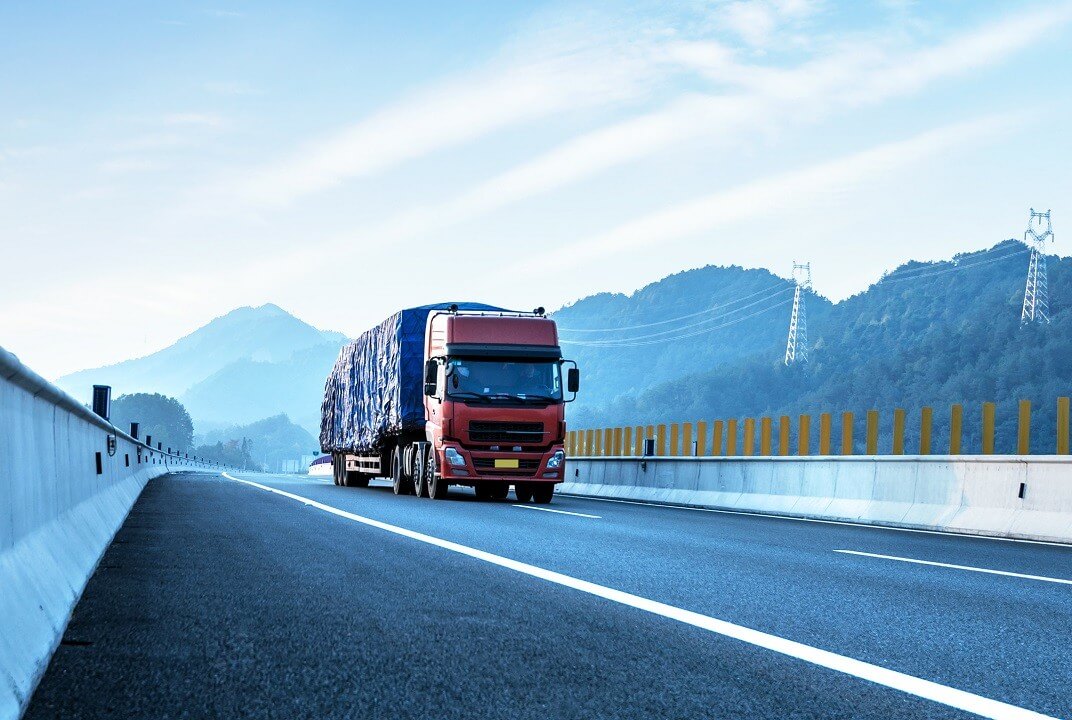 Red truck on the highway at high speeds.