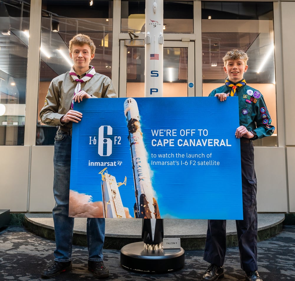 Two male scouts holding a banner celebrating that they will be a the launch in Cape Canaveral of Inmarsat-6 F2