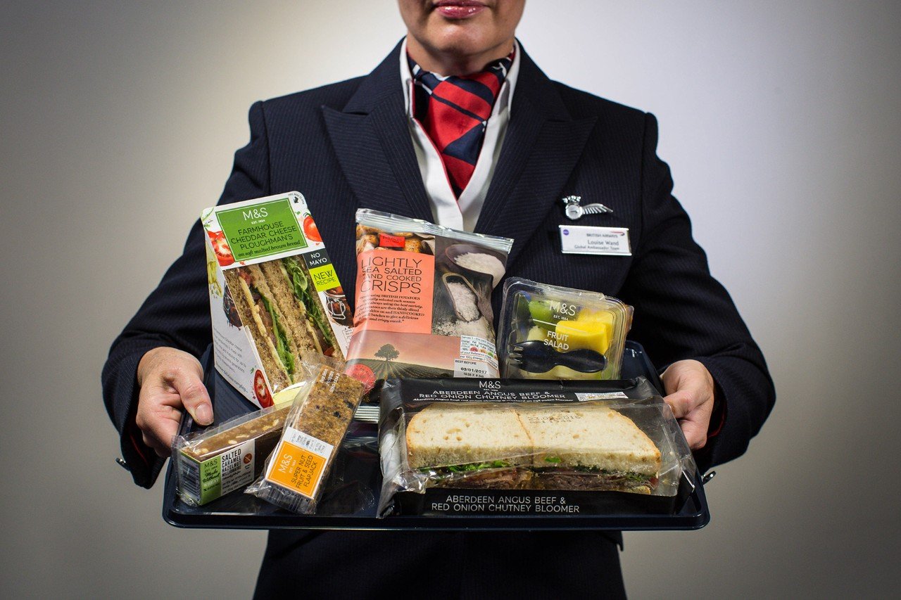 British Airways staff holding tray full of M&S food