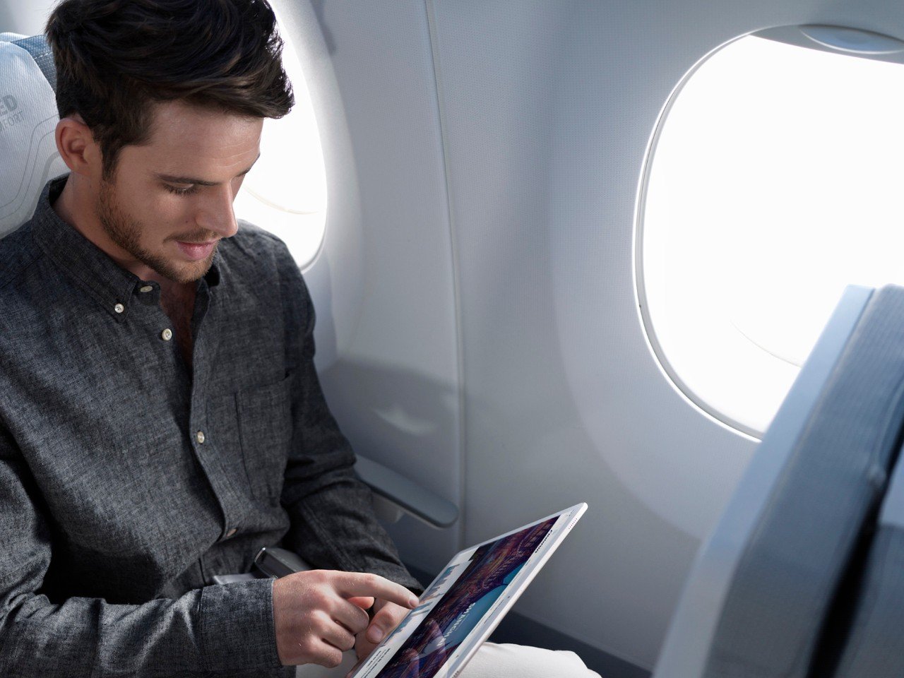 Passenger using a tablet in economy class onboard a Finnair A350