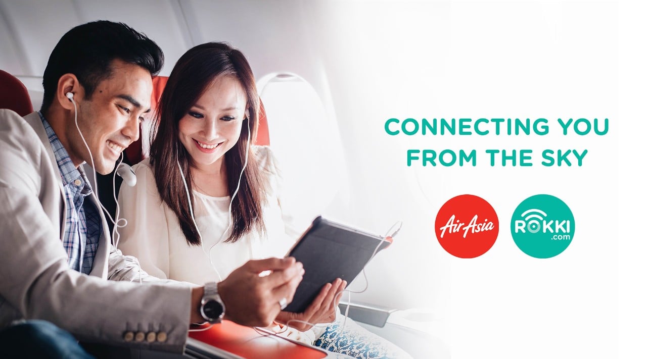 Couple using smart devices with AirAsia and Rokki logo