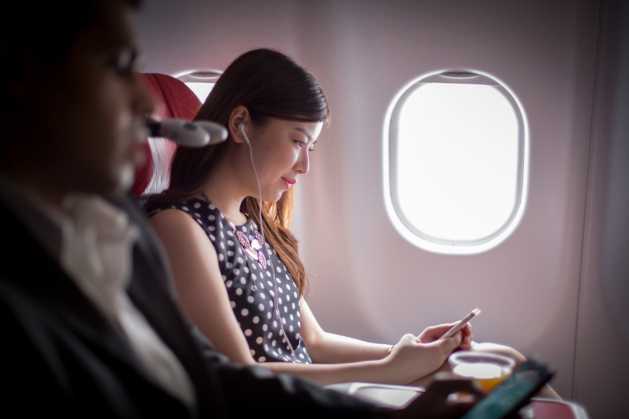 Woman using a smartphone on aircraft