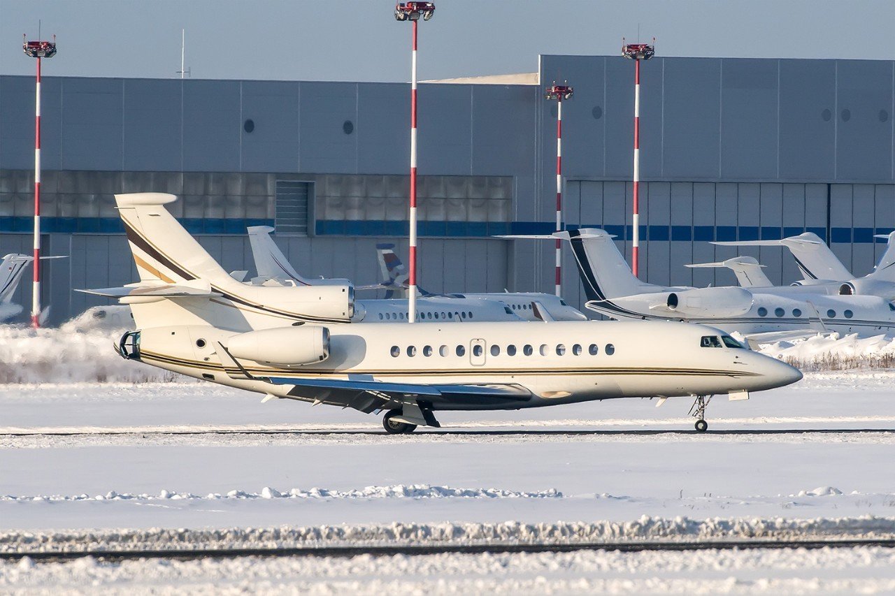 Falcon Jet taxiing through a snow covered airport