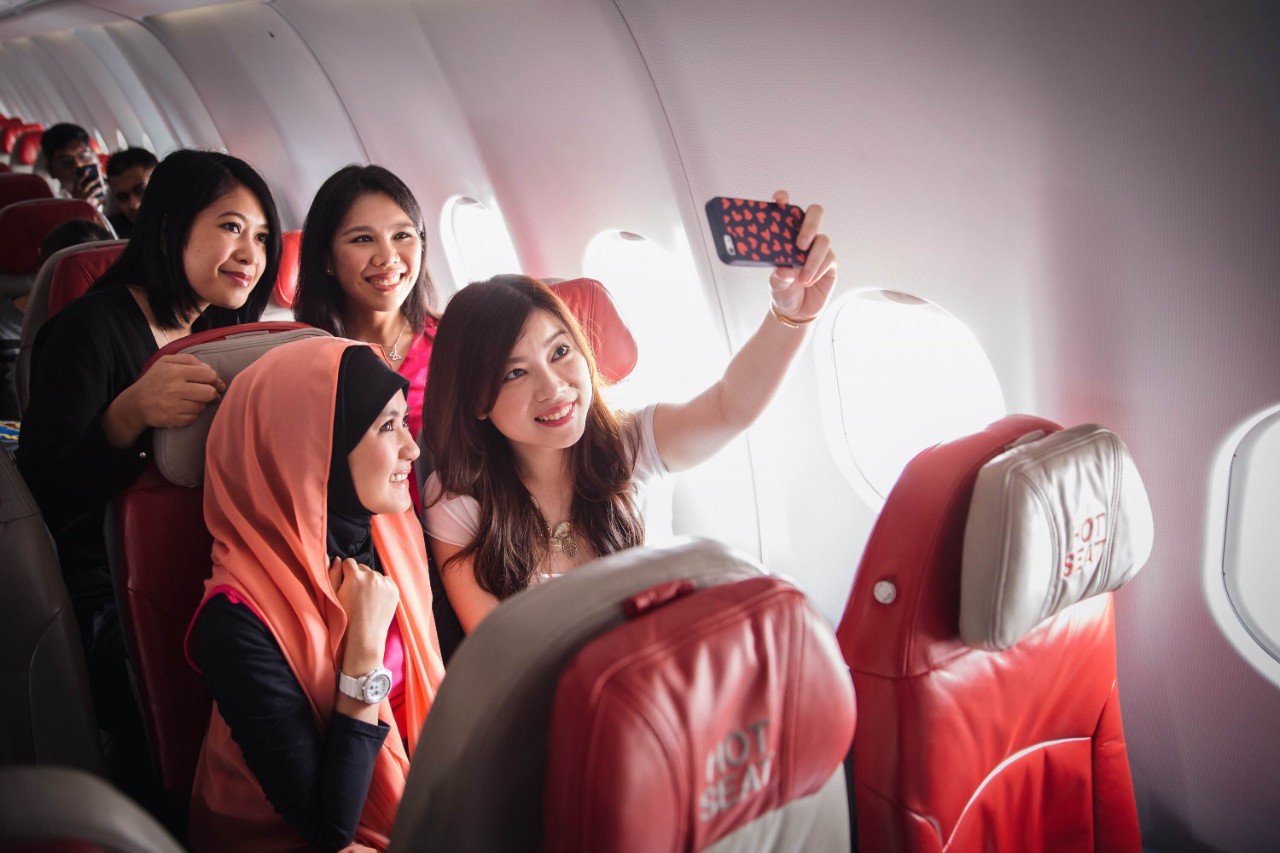 Passengers on an AirAsia aircraft using their mobile phone to take a selfie