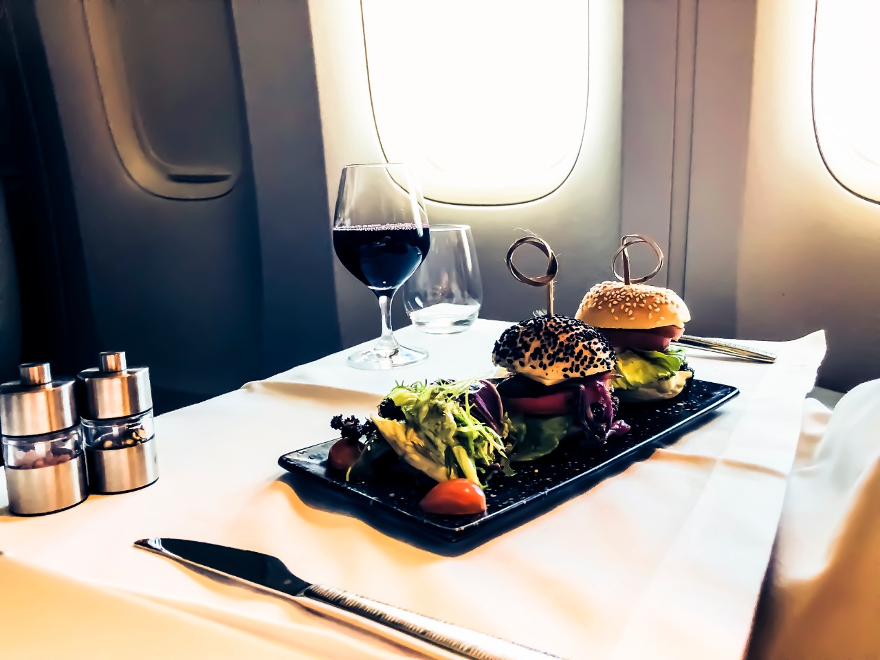 Luxury food served on an aircraft with a glass of wine and metal cutlery 