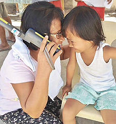A mother and child using a satphone provided by Inmarsat to make a call