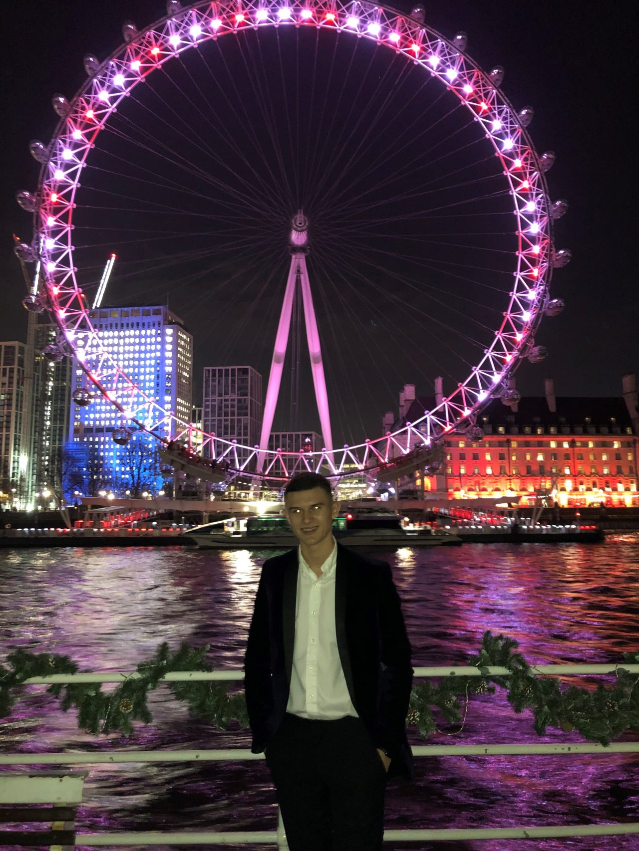 Inmarsat apprentice Ben Purser in front of the London Eye at nighttime attending an Inmarsat event