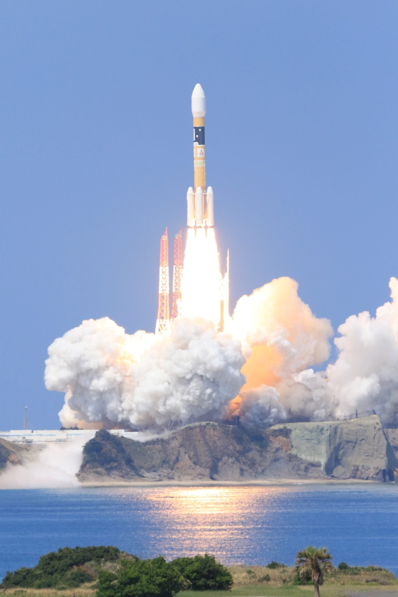 Rocket launching from the MHI JAXA Tanegashima Space Center, surrounded by smoke