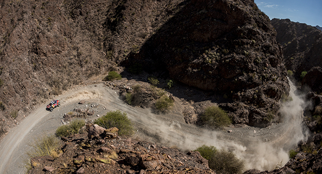 Car moving at high speed on an unpaved road on the Red Bull Dakar Rally