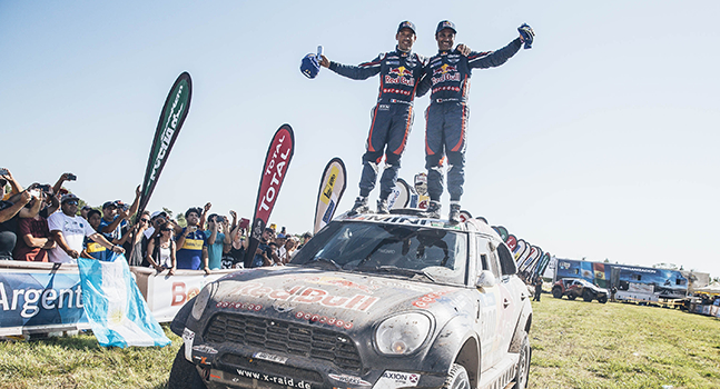 Red Bull Dakar Rally winners celebrating on top of their vehicle