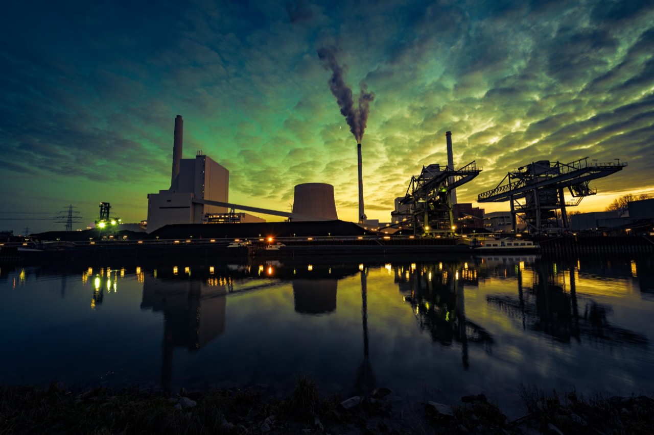 Power station silhouetted by sunlight