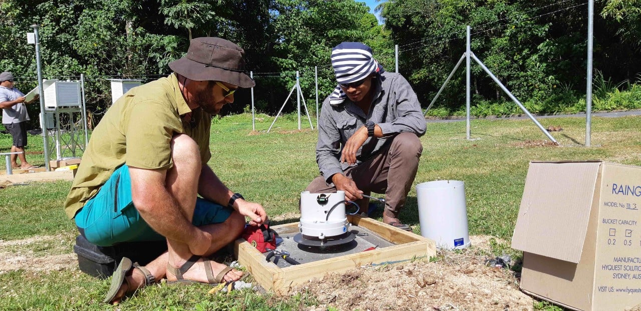 Connecting the sensors. Training is a large part of the Automatic Weather Stations construction and installation process and here, NIWA Technician Eric Stevens demonstrates the operation of a tipping bucket rain gauge to Tonga Meteorological Service staff (Jeremy Rutherford, NIWA)