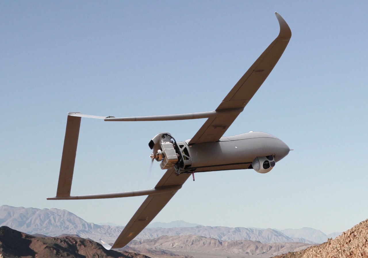 Military UAV inflight above rocky mountains