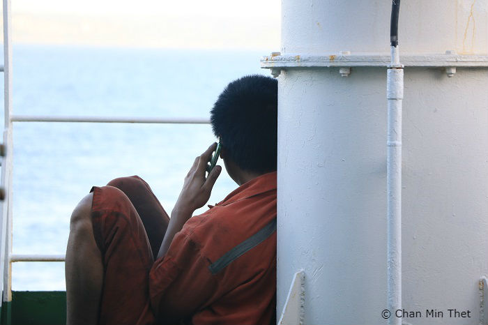 Seafarer using their phone whilst onboard