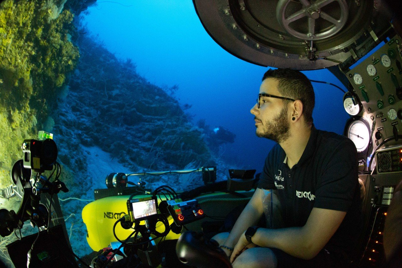 Member of the Nekton team exploring the coral reef from inside the submarine.