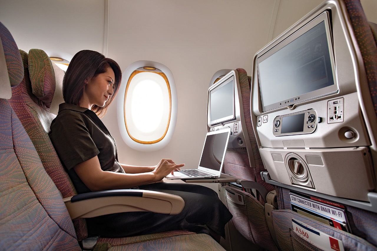 Emirates passenger using laptop on board aircraft