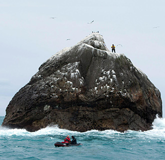 Nick Hancock on Rockall with his supply boat sailing away