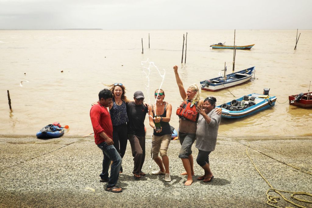 The adventurers celebrate reaching the Atlantic with representatives of the Wai Wai community. Credit: Jon Williams