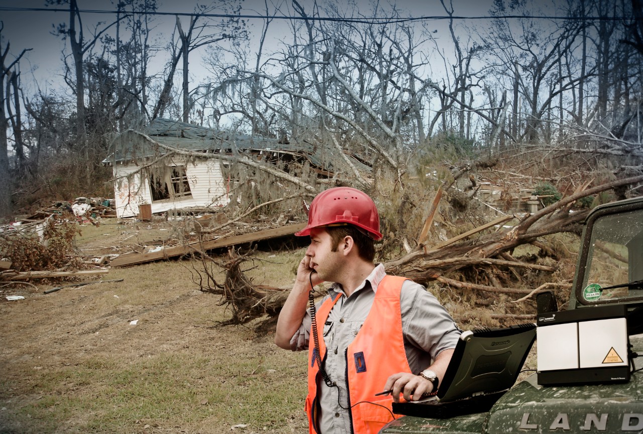 First responder in front of house destroyed by hurricane