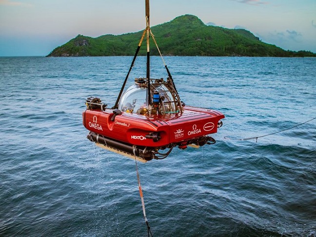 Nekton submersible being transferred between the ocean and main vessel.