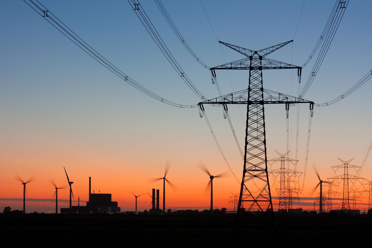 Pylons leading to a power station and wind turbines