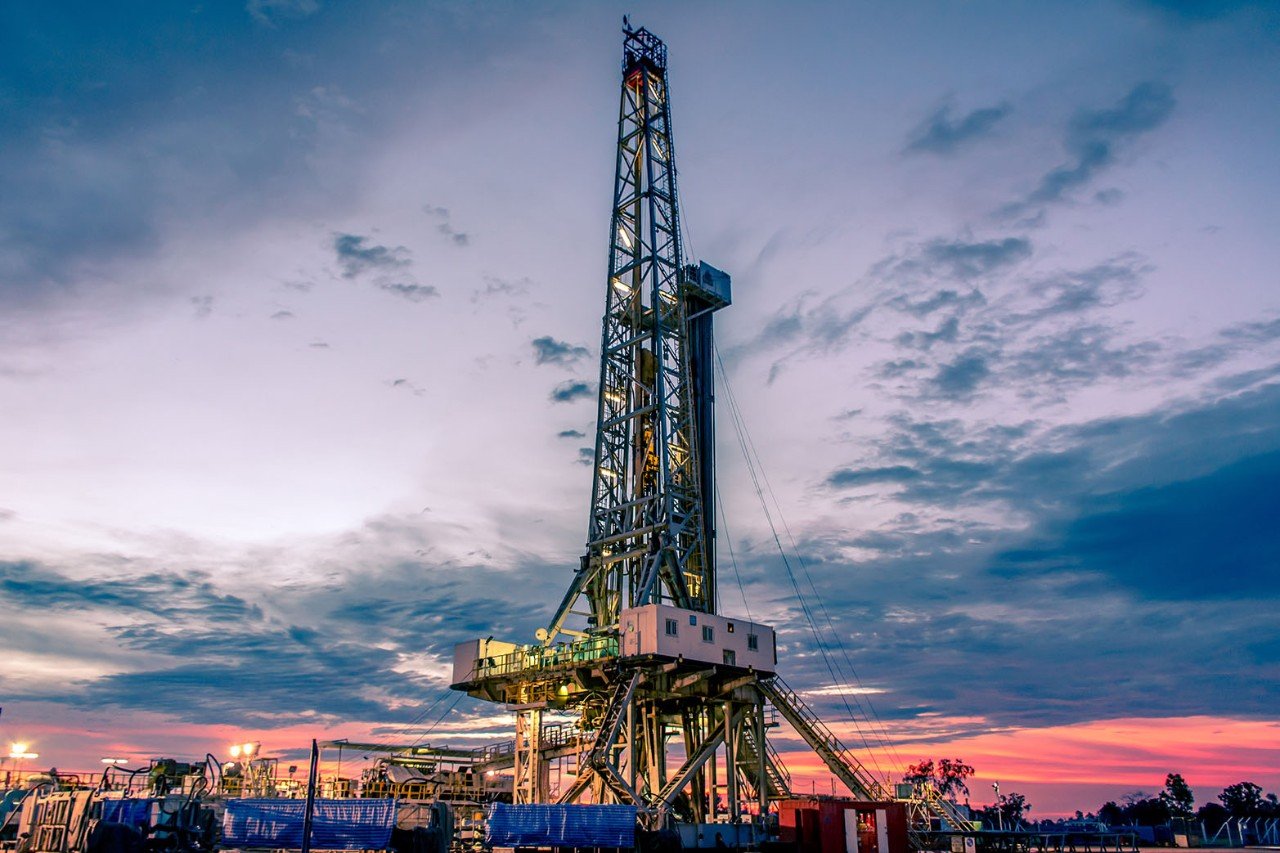 Wellhead drilling rig at dusk
